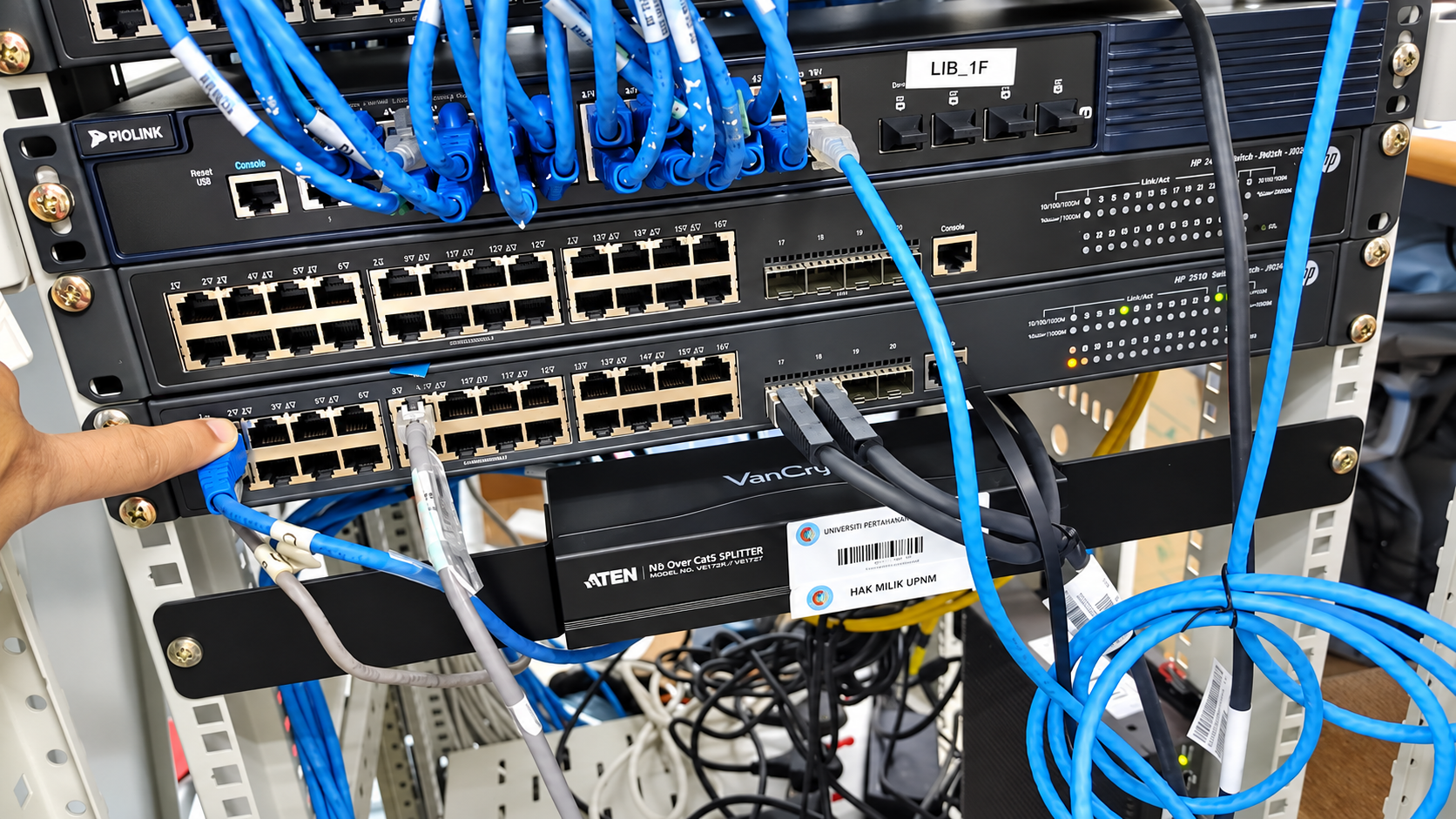 Technical team configuring network switches in the equipment rack